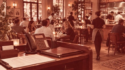 Illustrative restaurant phone at the host station during dinner service.