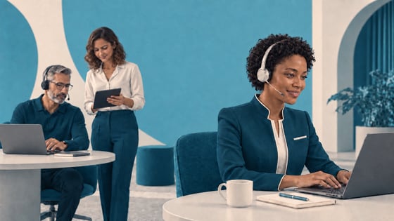 Call center agent in a tailored teal jacket and headset working at a laptop, with two colleagues collaborating behind her in a teal-and-cream office.