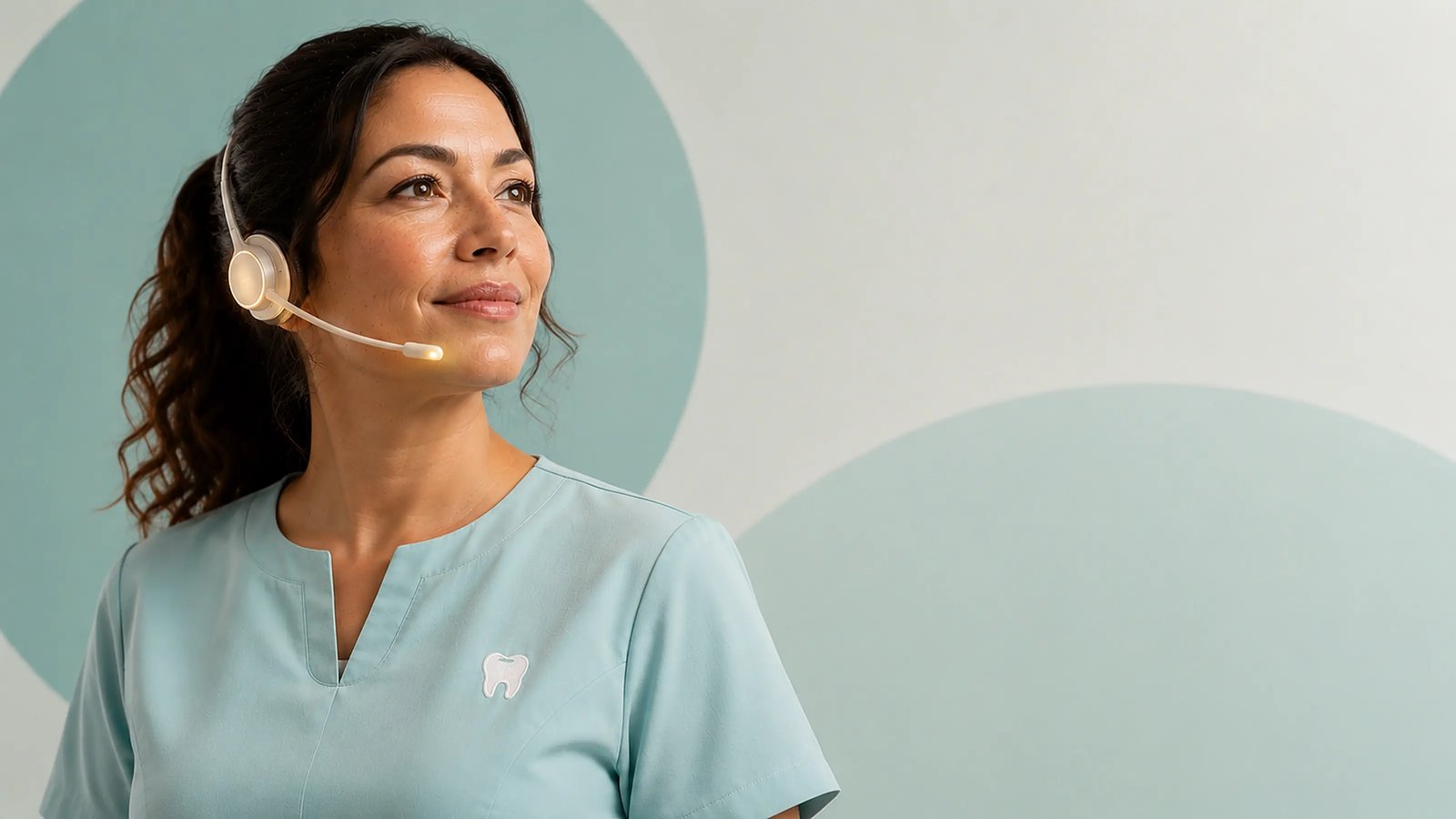A dental practice professional wearing a Newo communications earpiece, listening on a call